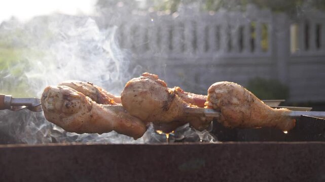 Chicken thighs are being grilled on the barbecue.