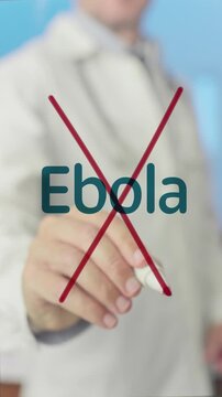 Medical professional crossing out the word ebola written on a clear board with a red marker, symbolizing the fight against the deadly viral disease and the search for a cure and prevention