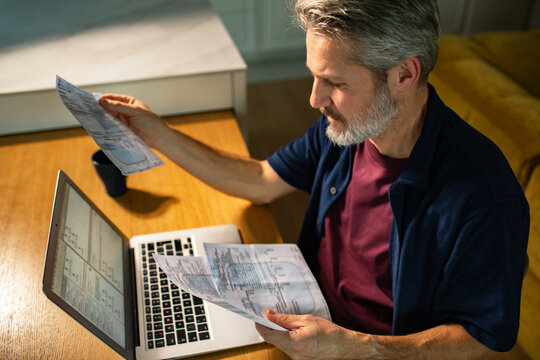 Middle-aged man reviewing bills at home office