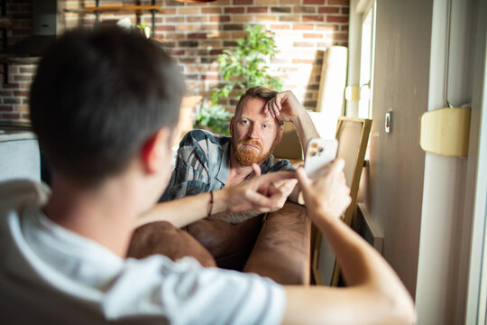 Two men discussing smartphone content at home