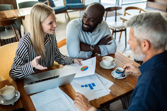 Coworkers reviewing financial charts in a cafe