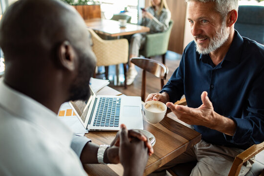 Two colleagues discussing business over coffee at cafe