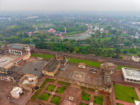 Aerial view of Lahore Fort featuring historic Mughal architecture, expansive courtyards, manicured green gardens, and surrounding parkland in Lahore, Punjab, Pakistan.