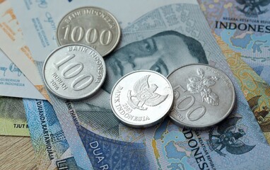 Indonesian rupiah money bills and coins on table. Indonesia cash of IDR currency © Larysa