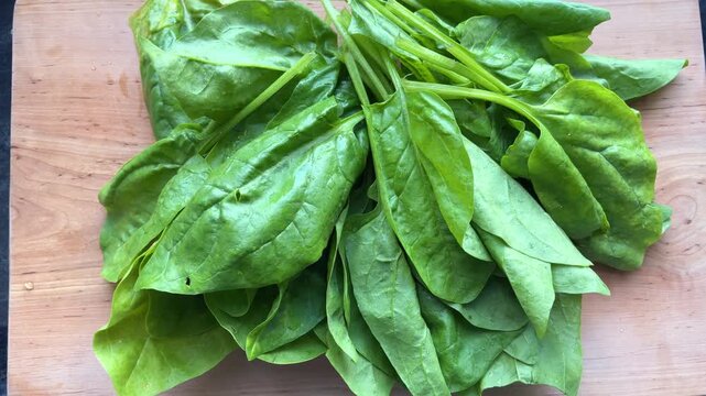 Fresh green spinach leaves on wooden board