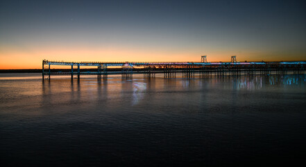 Fototapeta premium Illuminated mining pier over the Huelva estuary glowing in the golden hour