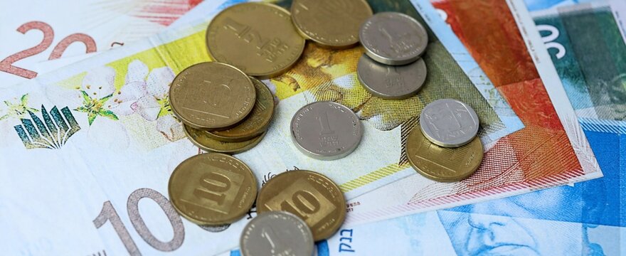 Israeli shekel money bills and coins on table. Israel cash of ILS currency close up