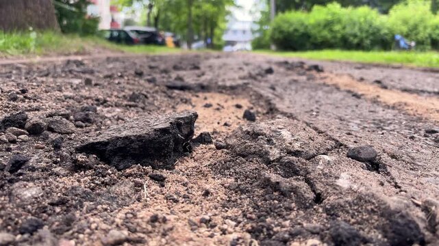 Crumbling asphalt road surface showing damage and deterioration