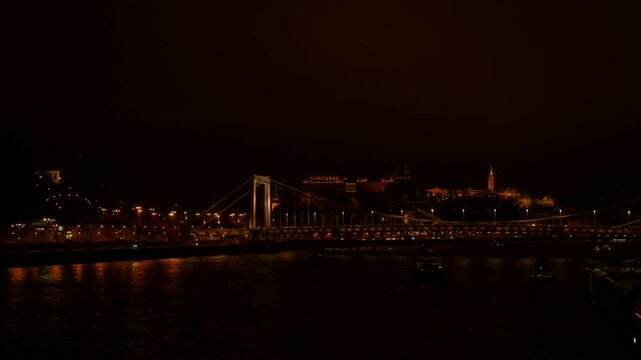 Elisabeth bridge illuminating budapest cityscape at night. Famous elisabeth bridge over the danube river illuminating the dark night sky with buda castle in the background, a cityscape of budapest