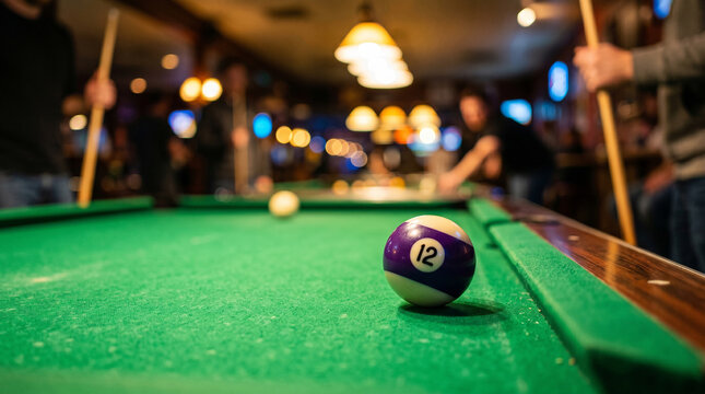 Close-up of number 12 pool ball on green table in a bar