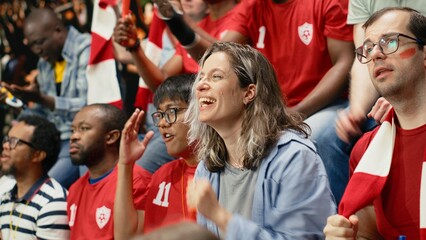 Passionate woman football supporter cheering with red team crowd in stadium stands during intense live soccer match, football equality and inclusion, sports fans celebrate with chants. © DC Studio