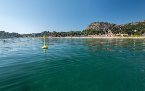 Yellow navigation buoy in calm coastal waters.