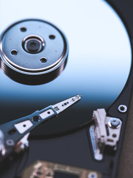 Hard drive internals showing platter and read arm in soft lighting.