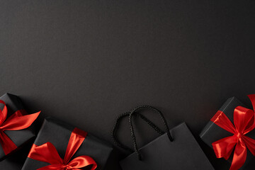 Fototapeta premium Black Friday and Cyber Monday black gift boxes with red bows and shopping bag on dark background