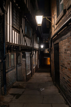 Lady Pecketts Yard in York at night a narrow medieval alleyway with ancient houses lit by old-fashioned street lamps