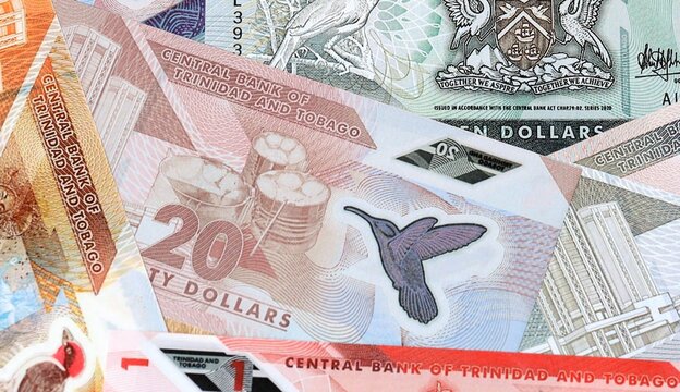 Trinidad and Tobago dollar money bills in pile on table. Trinidad and Tobago TTD currency cash
