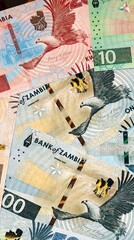 Fototapeta premium Zambian kwacha money bills in pile on table. Zambia ZMW currency cash close up