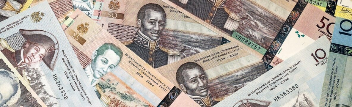 Haitian gourde money bills in pile on table. Haiti HTG currency cash close up