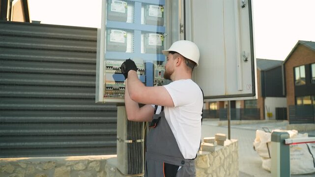 Electrician technician working on an electrical fuse box