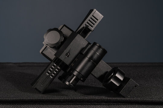 Black tactical night vision device helmet mount adapter with mini rail interface system close up on dark background