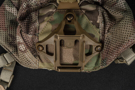 Tactical night vision shroud mounted on multicam camo skull cap head harness system close up isolated on dark background