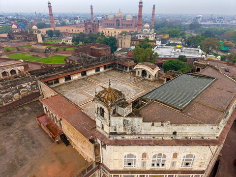 Aerial view of Lahore Fort featuring historic Mughal architecture, expansive courtyards, and intricate stone details with the Badshahi Mosque in the background in Lahore, Punjab, Pakistan.