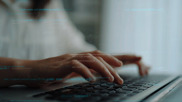 Close-up of hands typing on a laptop keyboard with an overlay of computer code and digital data, illustrating concepts of technology, programming, and modern workspace dynamics. Xenic