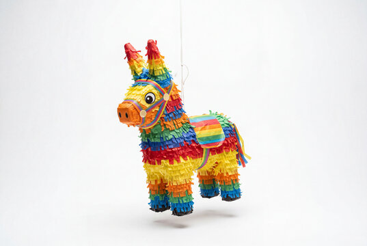Colorful rainbow paper donkey pinata hanging freely on a thin string completely isolated on white