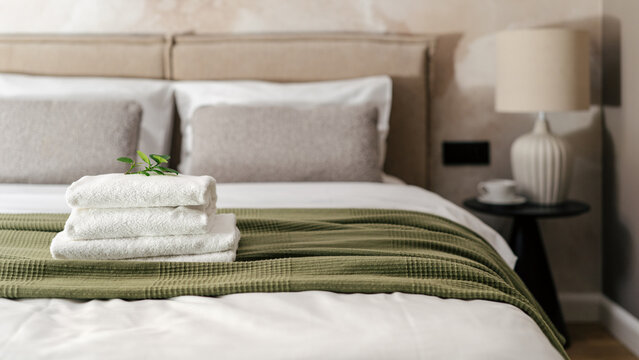 Towels on bed in modern hotel room ready for guests to enjoy their stay