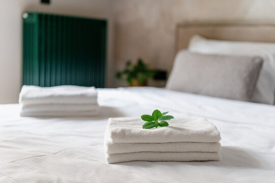 Clean white towels neatly placed on a hotel bed in a comfortable room