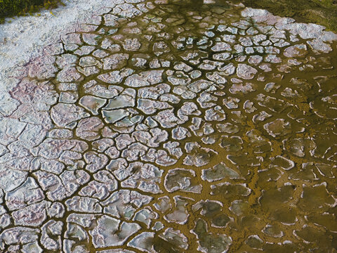Aerial view of the cracked, salt-crusted surface of a dried lake bed with intricate patterns and earthy tones in La Ventana, Baja California Sur, Mexico.