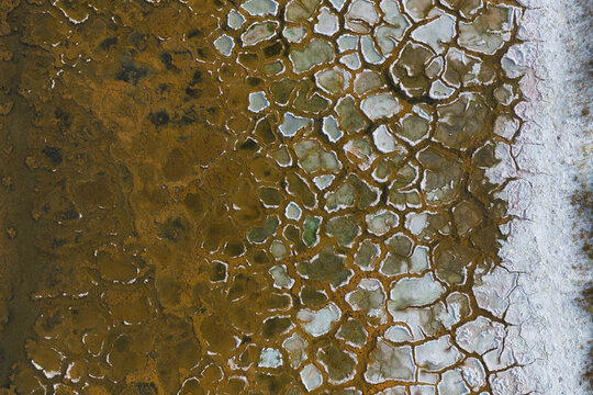 Aerial view of intricate cracked polygonal patterns and textured earth surfaces of the salt flats in La Ventana, Baja California Sur, Mexico.