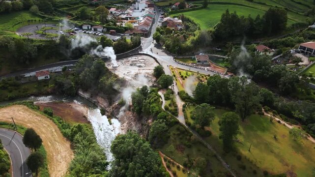 Geothermal hot springs and steaming fumaroles in valley town park landscape