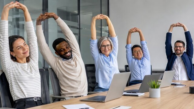Office workers stretching arms in conference room. Diverse business team practicing wellness and physical activity at workplace during break. Healthy corporate lifestyle and corporate culture