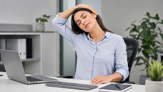 Woman office worker stretching neck to relieve pain while sitting at desk. Corporate employee doing exercise during work to release stress. Healthy lifestyle and ergonomics at workplace