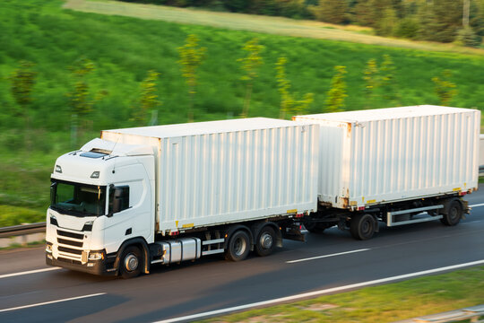White Semi-Truck Hauling Double Shipping Containers on Highway Route, The Concept of Intermodal Freight Logistics