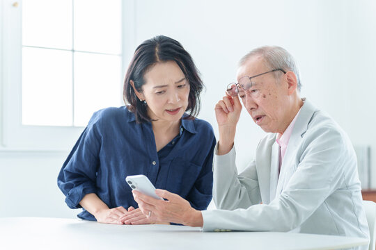 スマートフォンを学ぶ困った表情の高齢者男性