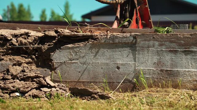 Close up view of a deteriorating concrete block cracking and breaking apart under pressure, with pieces and dust falling to the ground in a slow motion sequence of structural failure