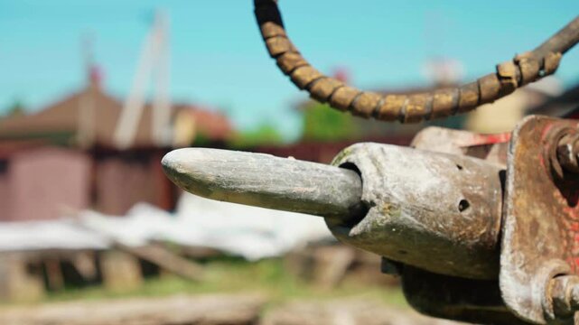 Close up of a powerful hydraulic breaker attachment vibrating during operation on a construction site, with demolition equipment and heavy machinery working in a shallow depth of field