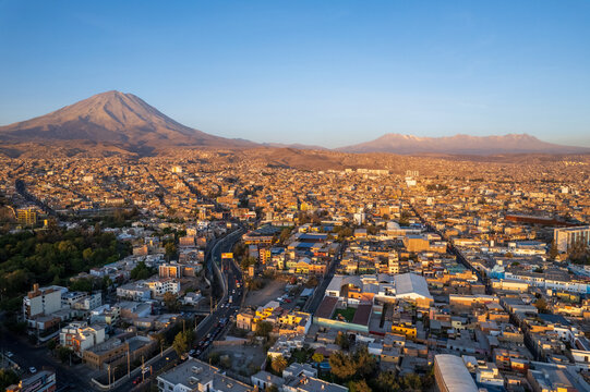 Aerial view of the city of Arequipa with the Misti volcano in the background during golden hour, featuring dense urban architecture in Arequipa, Arequipa, Peru.