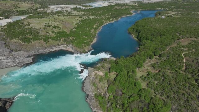 Aerial view showing the dramatic confluence of the Baker River and the Neff River in Patagonia, Chile, highlighting the intense color contrast between the turquoise glacial waters