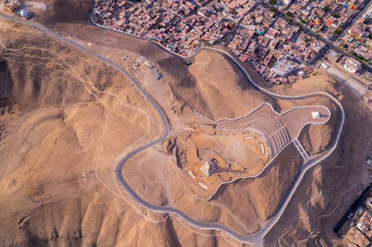 Aerial view of the ancient adobe pyramid and archaeological ruins of Huaca Pucllana surrounded by the urban sprawl of Lima, Provincia de Lima, Peru.
