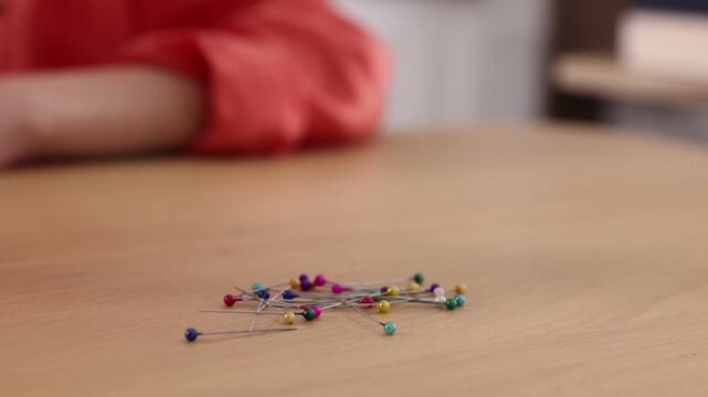 Student showing effect of magnetic field using horseshoe magnet and sewing pins at physics lesson in classroom, closeup