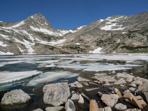 Mount Toll reflected in partially frozen Blue Lake, Indian Peaks Wilderness, Colorado