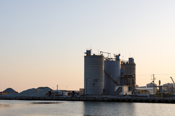 夕日に染まる高砂工業地帯の港とサイロ（兵庫県高砂市） © walkingcow3039