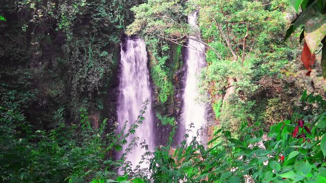 Two beautiful waterfalls Curug Cinulang West Java Indoneisa among rocks and the green scenery of trees 