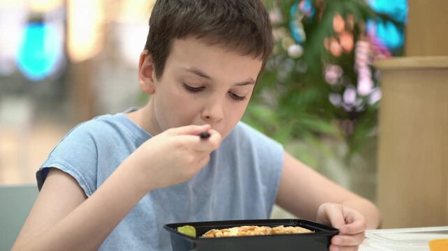 Child eating fresh Caesar salad with chicken at a food court, capturing healthy food, casual dining and authentic family moments.