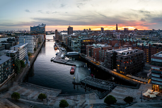 Aerial view of HafenCity in Hamburg, featuring the Elbphilharmonie, modern architecture, canals, and boats at sunset in Hamburg, Hamburg, Germany.