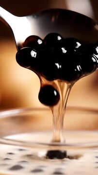 Shiny blackberries rest on a spoon in glossy, ripe detail