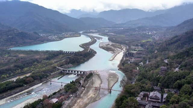 A historic water conservancy project in mountainous terrain, with divided river channels and surrounding vegetation.